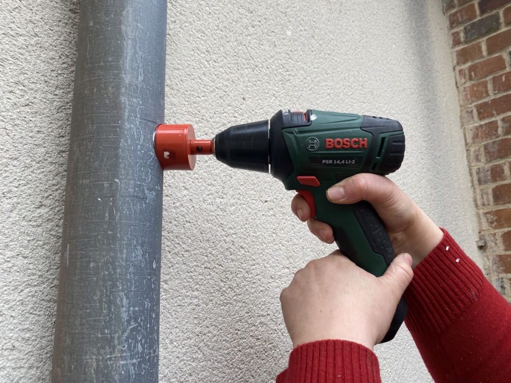percer la gouttière avec la scie cloche montée sur une perceuse